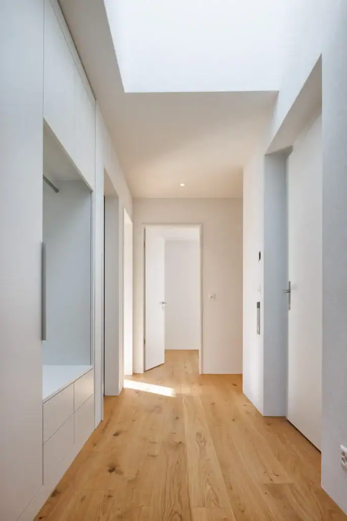 Hochwertige Materialien, ein grosszügiges Oberlicht und klare Linien schaffen einen hellen, einladenden Eingangsbereich mit zeitloser Eleganz.